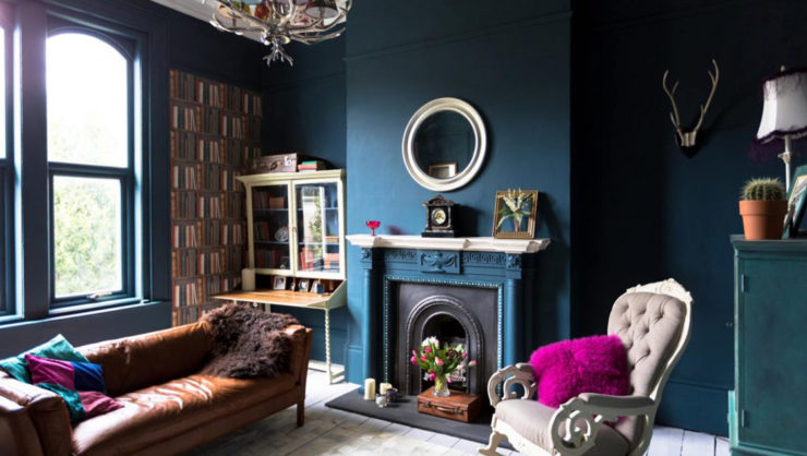 A living room with blue walls and a fireplace.